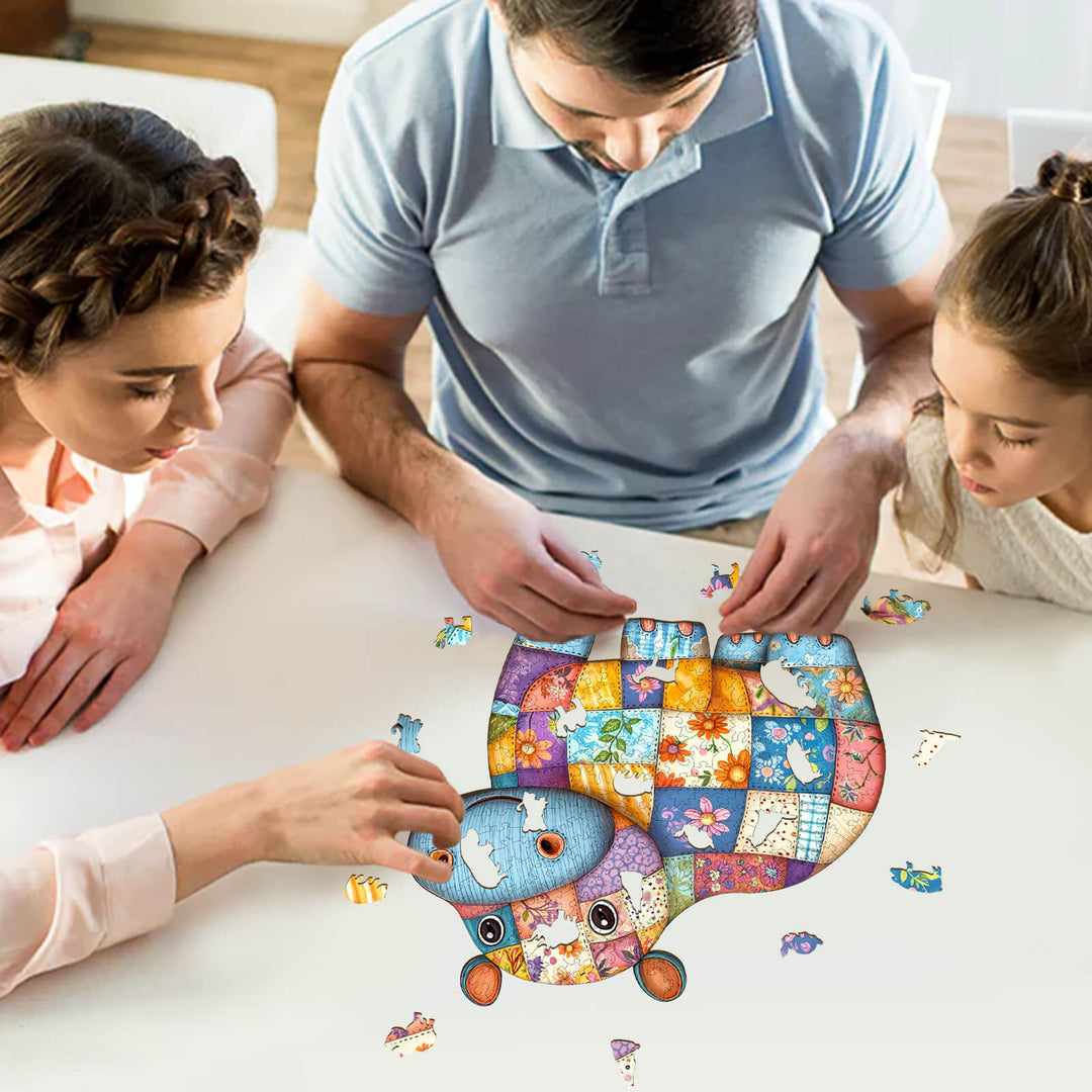Family enjoying a fun time solving the Patchwork Hippo wooden jigsaw puzzle together on a table.