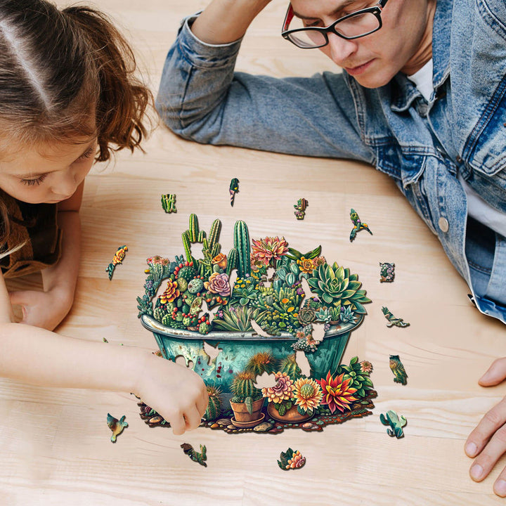 Father and daughter enjoying the SEEK AND FIND MANTISES wooden jigsaw puzzle with colorful greenery and succulents.
