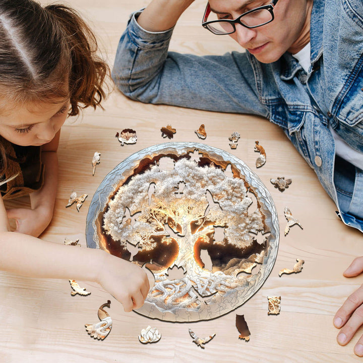 A father and daughter assembling a 3D glowing tree of life wooden jigsaw puzzle on a wooden table.