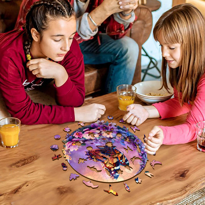 Two girls working on the Butterfly and Moon-1 wooden jigsaw puzzle on a table, surrounded by puzzle pieces.