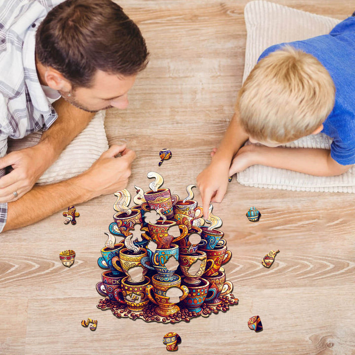 Father and son enjoying the Coffee Dreams wooden jigsaw puzzle of colorful tea cups on the floor.