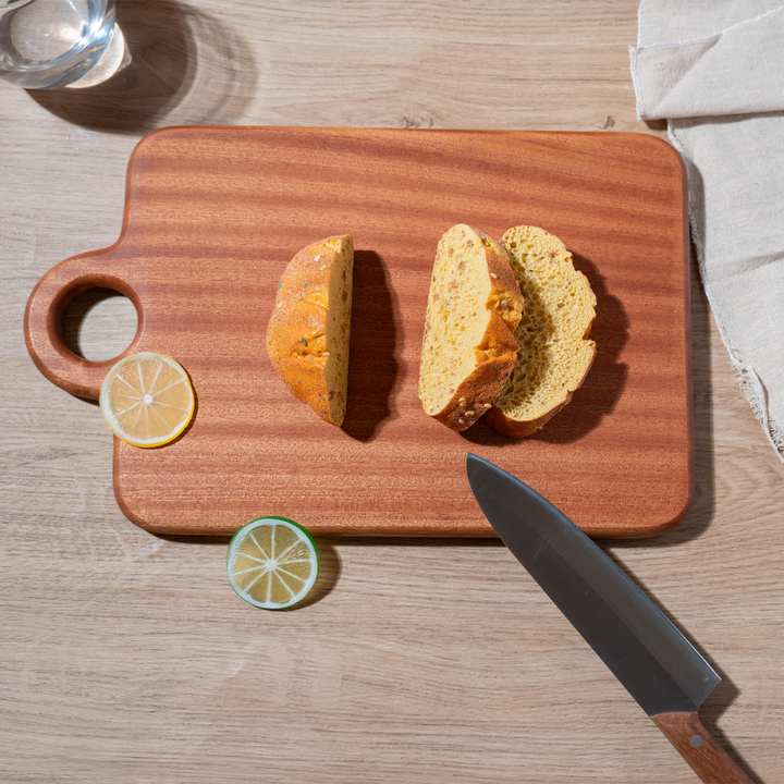 Polished wooden cutting board with sliced bread and lemon, perfect for kitchen use.
