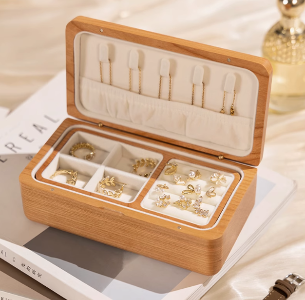 Elegant wooden double-layer jewelry box, showcasing organized rings and earrings in a stylish design.