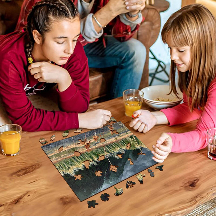 Two girls enjoying a puzzle featuring autumn leaves, sitting around a table with drinks and snacks.