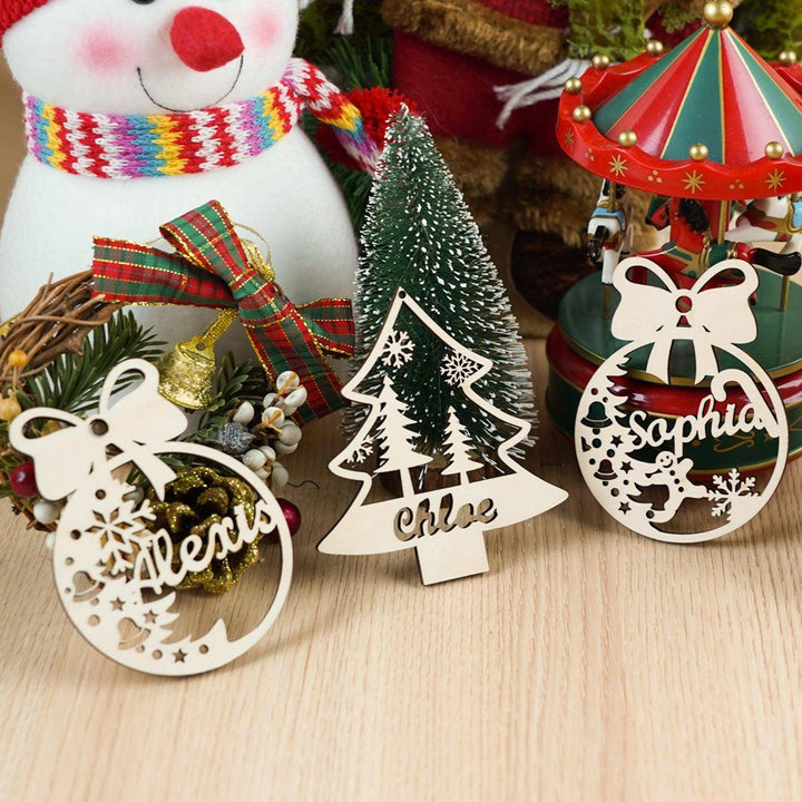 Personalized wooden Christmas ornaments featuring names Alexis and Sophia alongside a Christmas tree decoration.