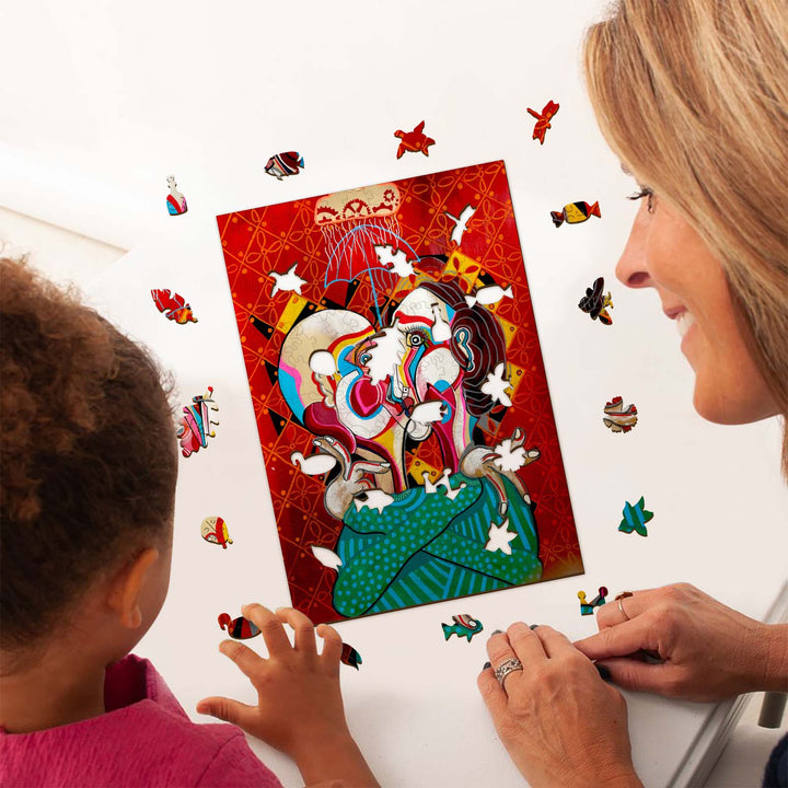 A woman and child admire the vibrant art piece 'A Moment in Time' by Dylan Gill, surrounded by colorful puzzle pieces.