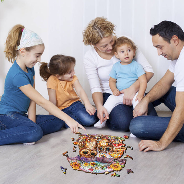 Family enjoying the Umbrella Owls wooden jigsaw puzzle together on the floor, promoting focus and fun for all ages.