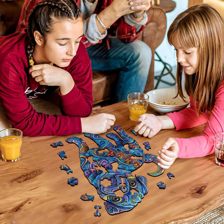 Two girls focused on assembling a colorful Cute Pug-2 wooden jigsaw puzzle at a wooden table, promoting mind engagement.