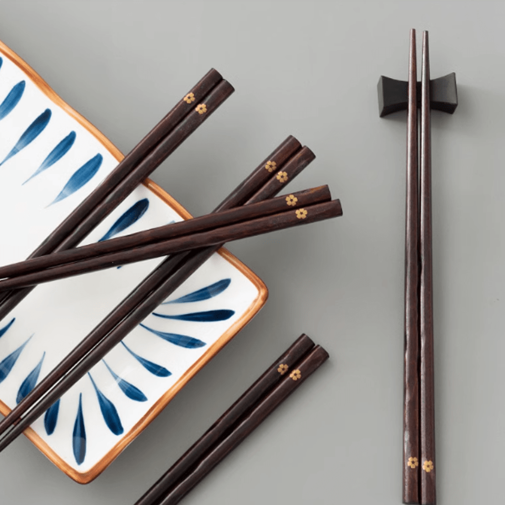 Non-slip Sakura wooden chopsticks set displayed on a decorative dish, showcasing elegant design and cherry blossom tips.
