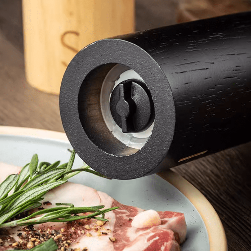 Close-up of a sea salt and pepper grinder showcasing its natural rubber wood design and mechanism on a dining table.