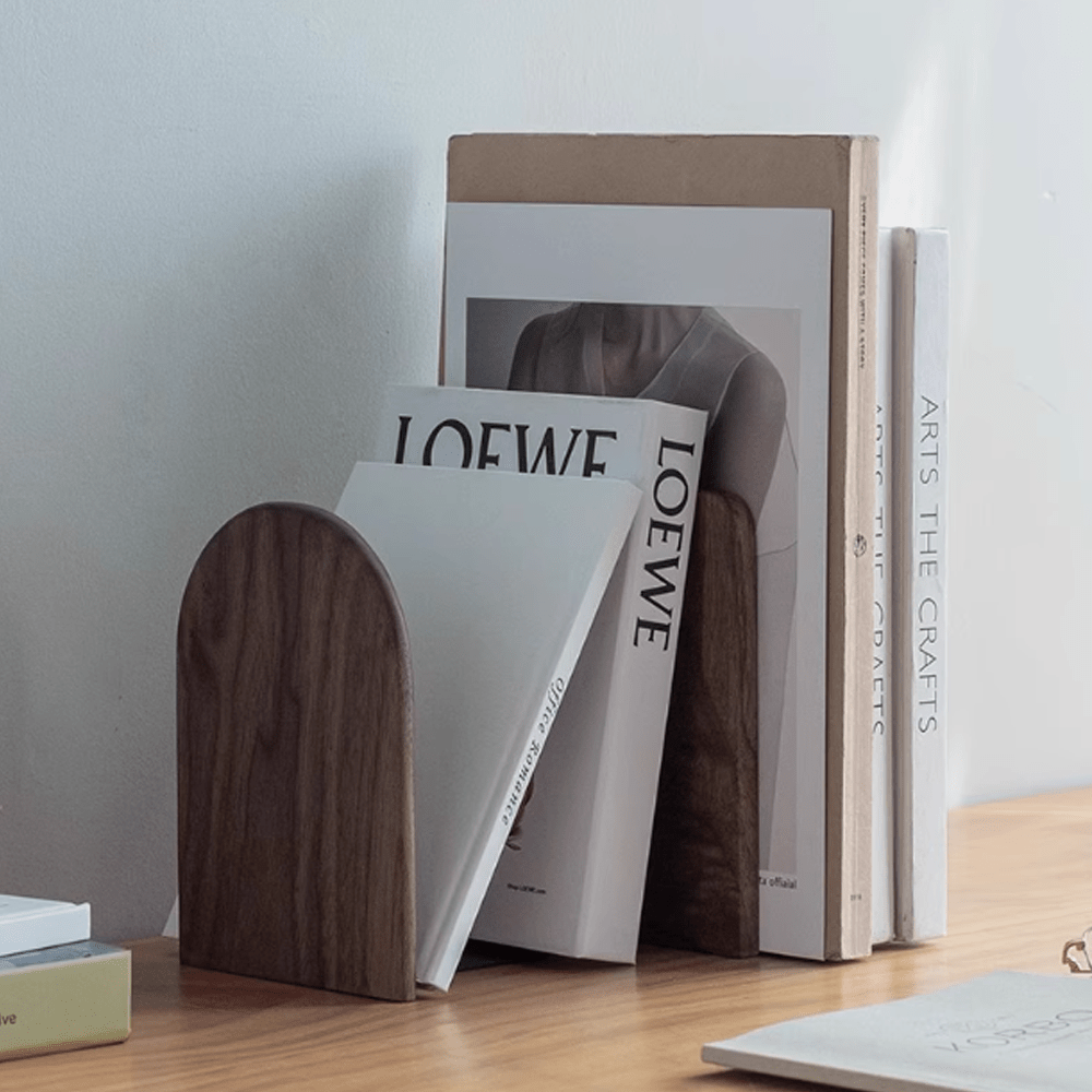 Elegant wooden bookends in walnut and beech, stylishly supporting books on a wooden desk.
