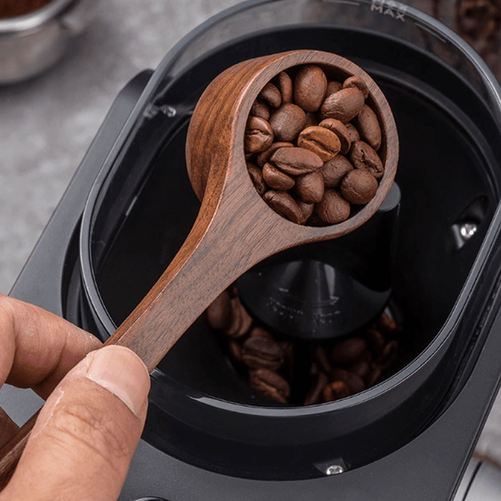 Wooden measuring spoon with coffee beans, perfect for precise measurements in cooking and baking.