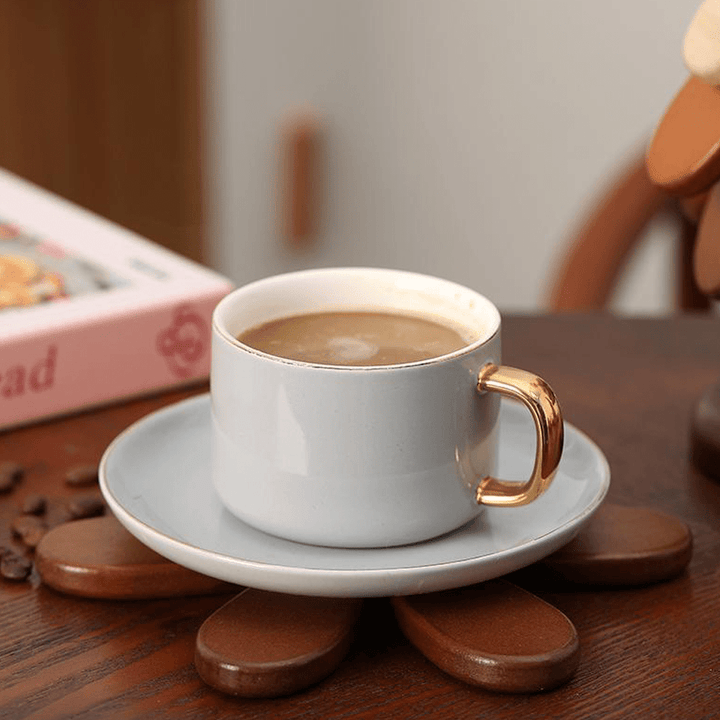 Coffee cup on a wooden Christmas tree coaster, showcasing elegant design and natural wood texture.