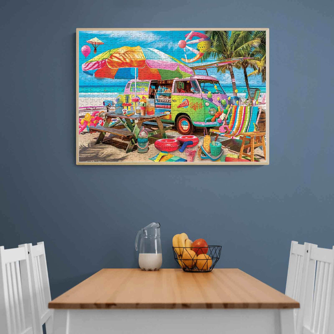 Colorful beach food truck puzzle displayed on a wall above a wooden table with fruits and chairs.