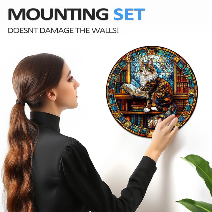 Woman mounting the Maine Cat Library puzzle on a wall without causing damage, featuring a colorful cat design.