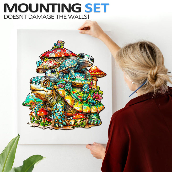 Woman hanging the Turtle Family Wooden Jigsaw Puzzle print on the wall, showcasing vibrant colors and sea turtle design.