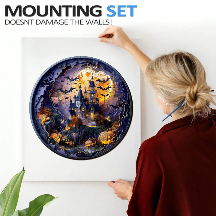 Person hanging a 3D Halloween Castle wooden jigsaw puzzle with a mounting set that doesn't damage the walls.