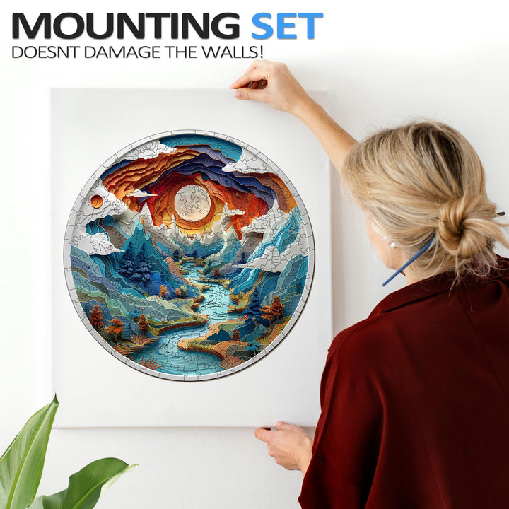 Person hanging a 3D cave-themed jigsaw puzzle art using a mounting set that doesn't damage walls.