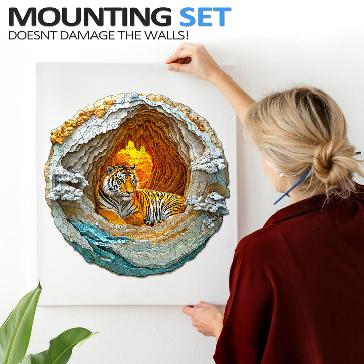 Woman mounting a 3D Tiger puzzle in a cave design on the wall without damaging it.
