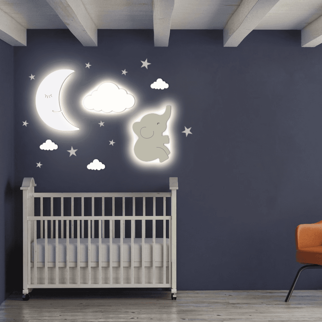 Moon and Cloud Wall Light above a crib in a nursery, featuring an elephant design and star accents.