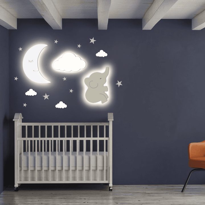 Moon and Cloud Wall Light above a crib in a nursery, featuring an elephant design and star accents.