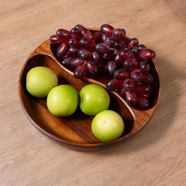 Organic wooden dinner plate with green apples and red grapes, showcasing natural elegance and healthy dining.