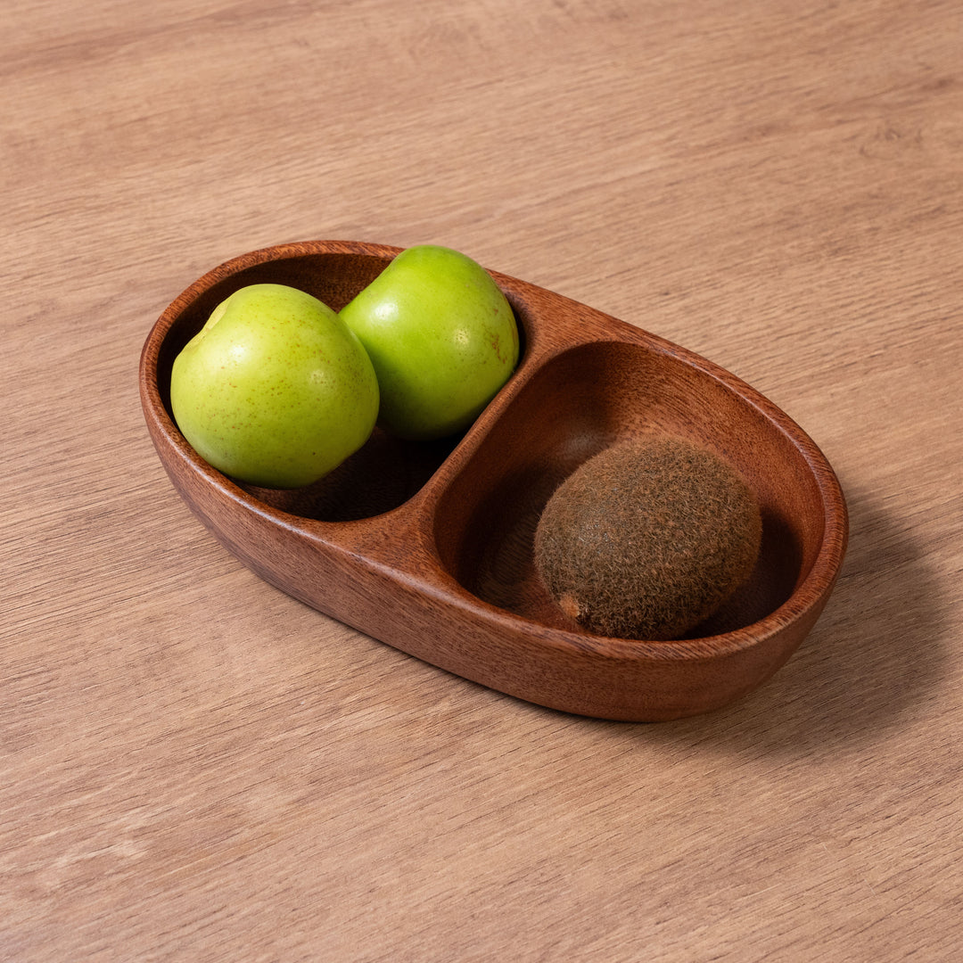Organic acacia wood bowl holding two green apples and a kiwi, showcasing natural materials for elegant dining.