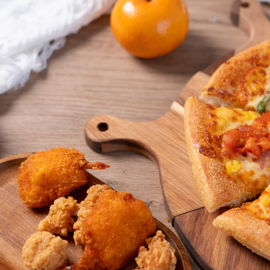 Delicious pizza and fried chicken served on a stylish acacia wood serving tray, perfect for sharing at gatherings.