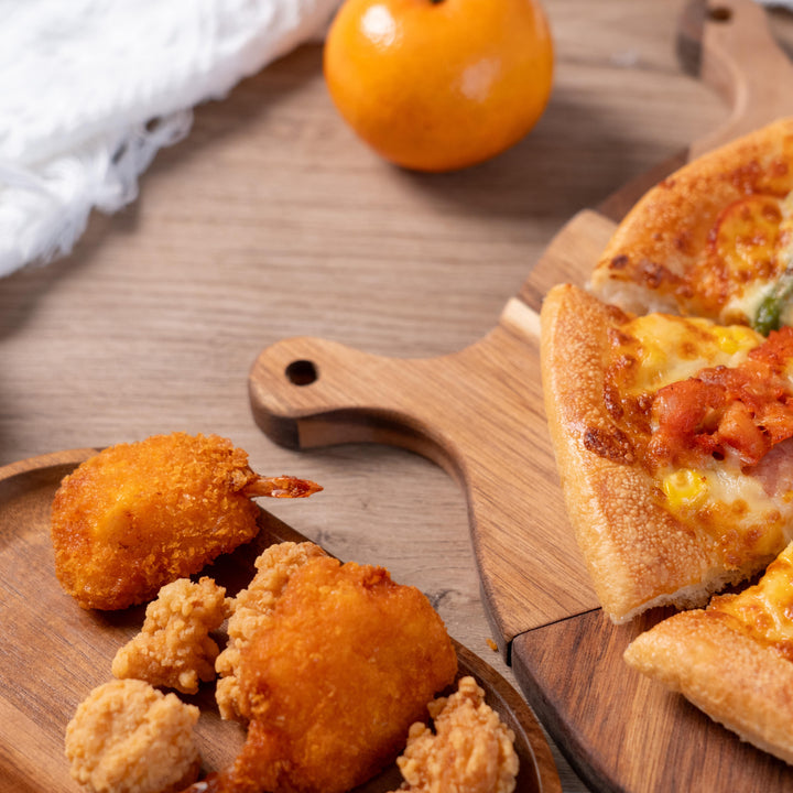 Delicious pizza and fried chicken served on a stylish acacia wood serving tray, perfect for sharing at gatherings.