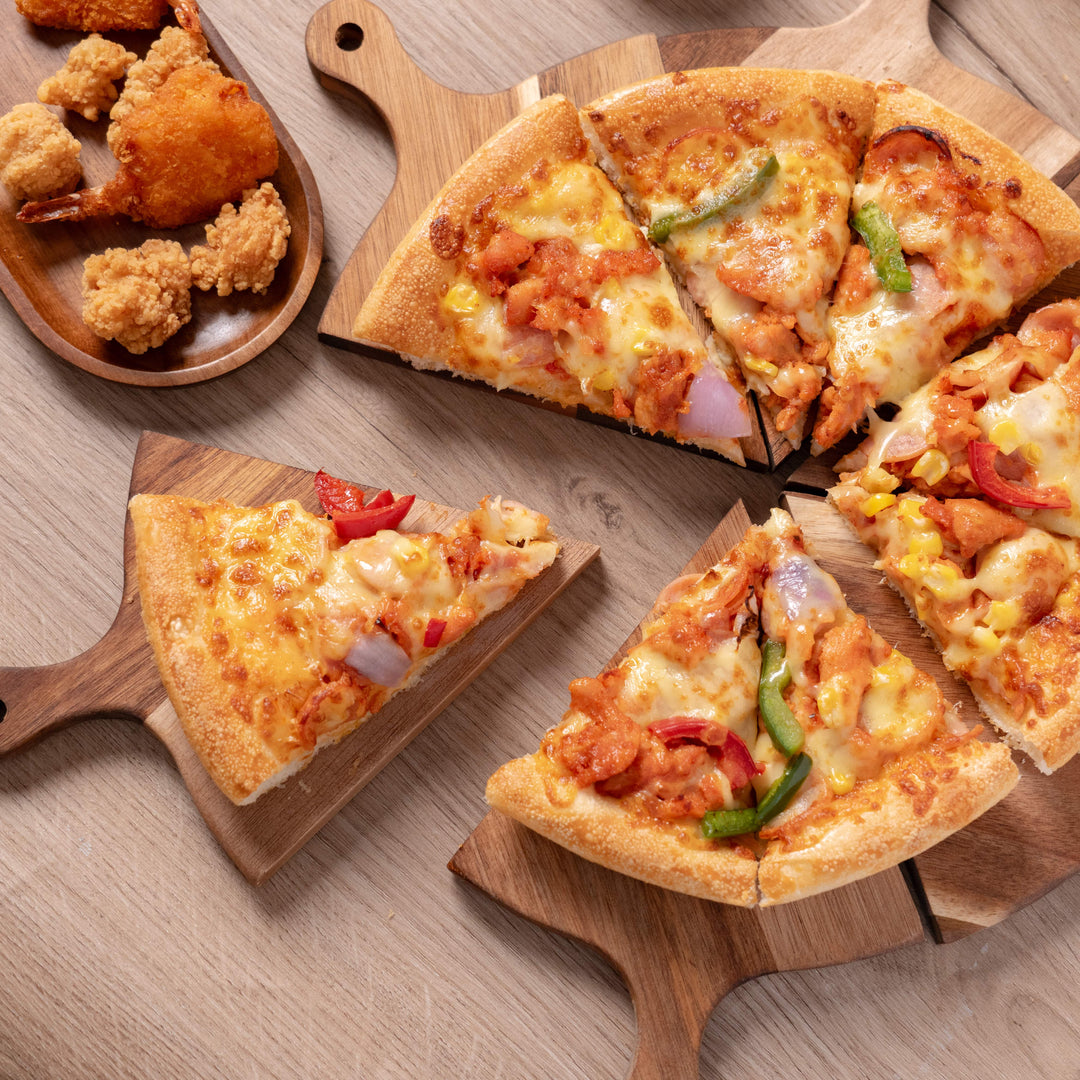 Acacia wood pizza serving tray with slices of chicken and vegetable pizza, perfect for sharing at any gathering.