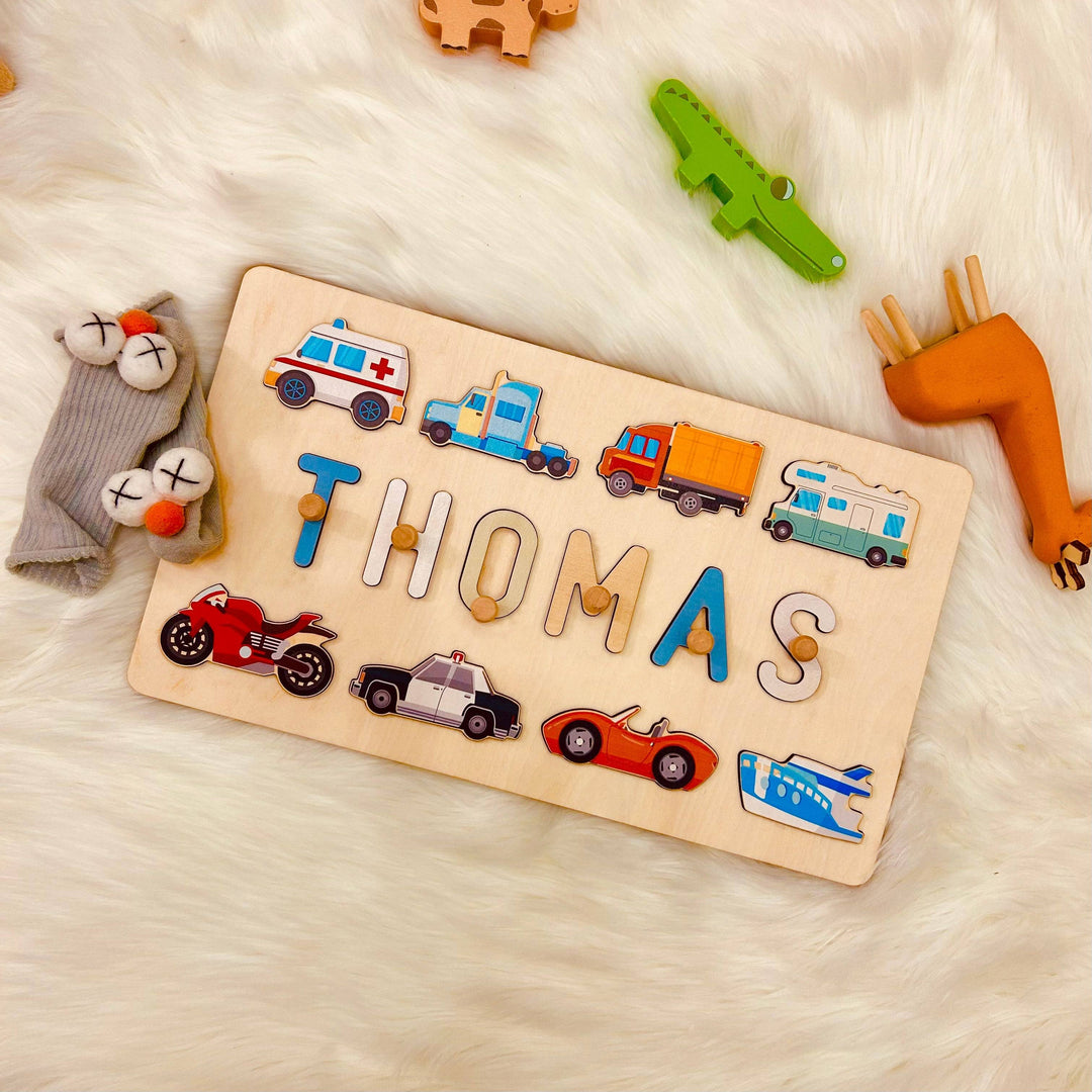 Personalized wooden baby name puzzle with traffic-themed icons spelling 'THOMAS' on soft fur background.