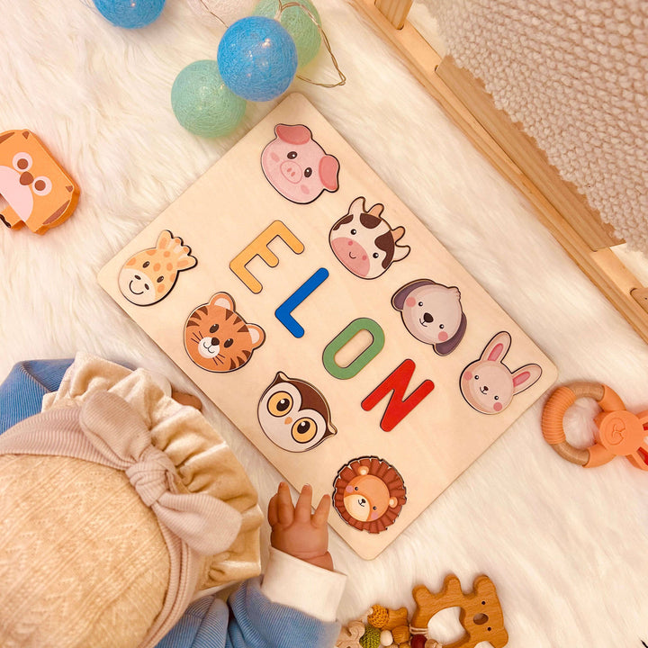 Personalized wooden baby name puzzle featuring colorful letters and animal icons for the name ELON.