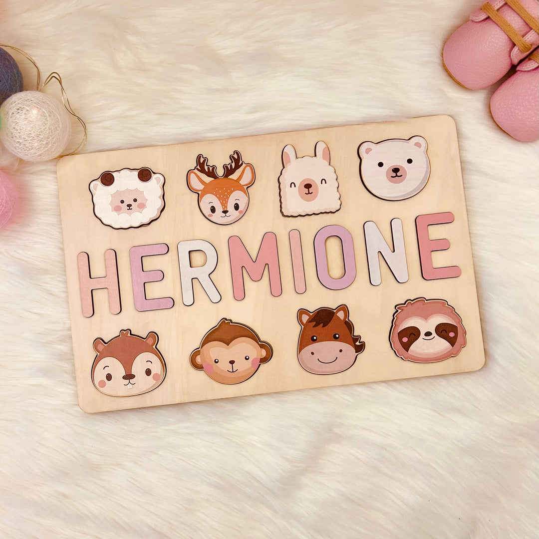 Personalized wooden baby name puzzle with animal graphics, featuring the name 'HERMIONE' in pastel colors.