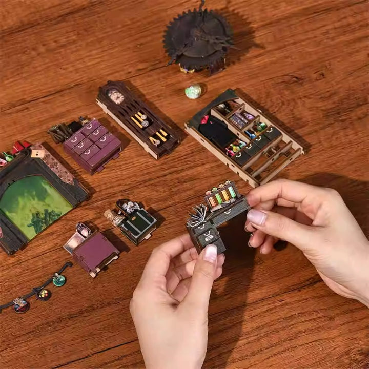 Hands assembling the Magic Apprentice's Research Room DIY book nook kit with detailed miniature furniture.