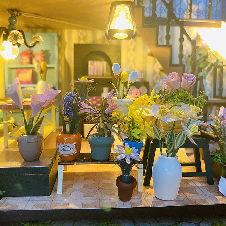 Colorful display of miniature flower pots inside a DIY dollhouse kit, showcasing a cozy interior design.