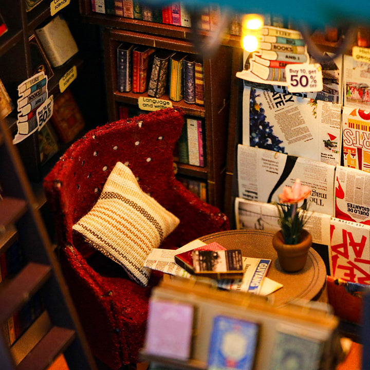 Cozy reading nook with a red chair, bookshelves, and a small table adorned with books and a potted plant.