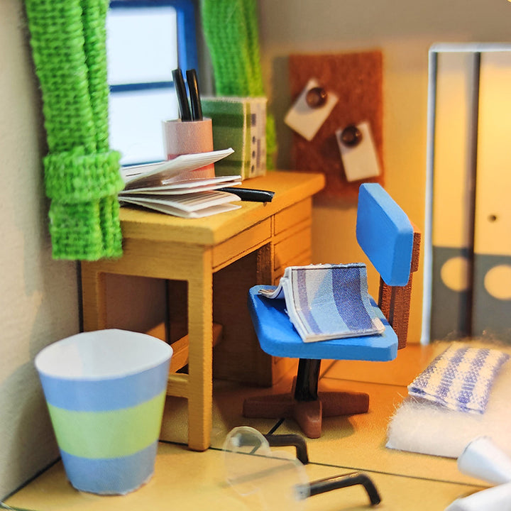 Miniature DIY dollhouse room with a desk, blue chair, and decorative details, perfect for creative adults and teens.