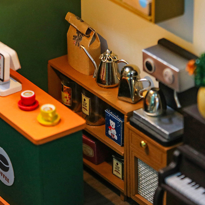Miniature coffee shop interior from Lucky Cafe House DIY Dollhouse Kit, featuring coffee equipment and vibrant colors.