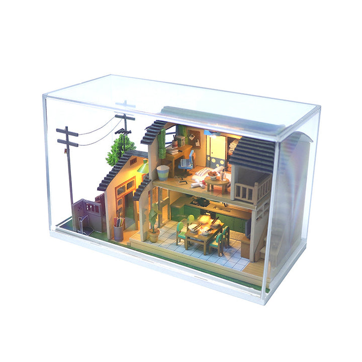 Japanese-style DIY dollhouse kit displayed in a clear case, showcasing intricate wooden puzzle details and a cozy interior.