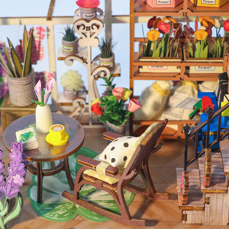 DIY Book Nook Kit featuring a cozy chair, flowers, and a table with music-themed decor in a charming garden setting.