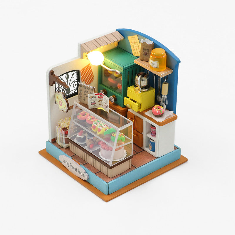 Mini house DIY dollhouse kit displaying a detailed sweet shop interior with colorful decor and miniature food items.