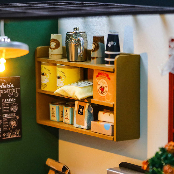 Miniature wooden coffee shelf with decorated boxes and a teapot in a DIY dollhouse kit.
