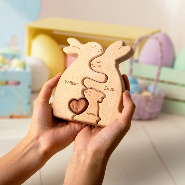 Customized wooden rabbit family name puzzle held in hands, featuring names William, Emma, and James.