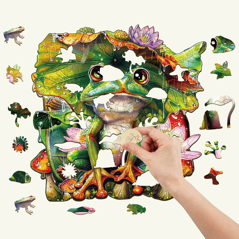 Colorful Frog Wooden Jigsaw Puzzle with a hand placing a piece, ideal for improving focus and cognitive skills.