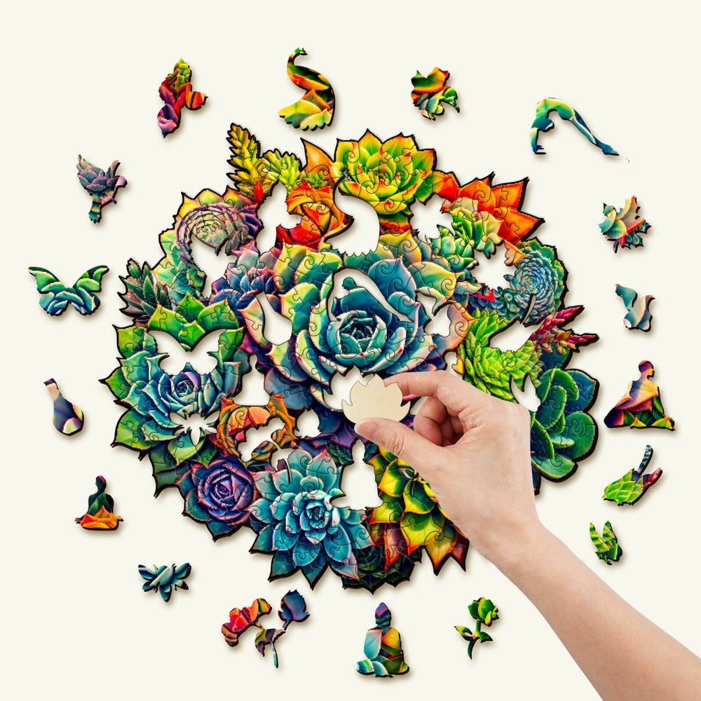 Person assembling a vibrant succulent plants wooden jigsaw puzzle, focusing on intricate, colorful pieces.