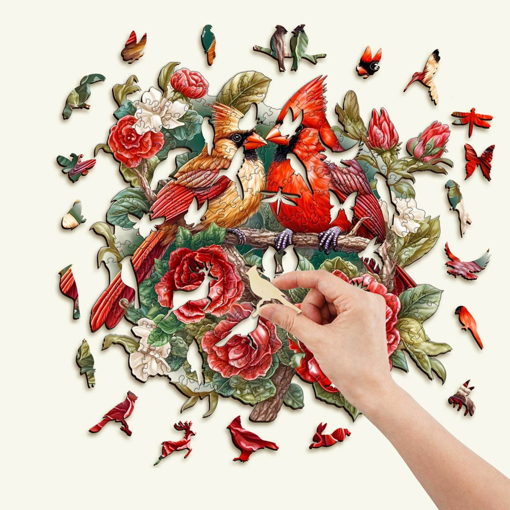 Hand assembling a Beautiful Cardinal Wooden Jigsaw Puzzle featuring vibrant colors and unique animal shapes.