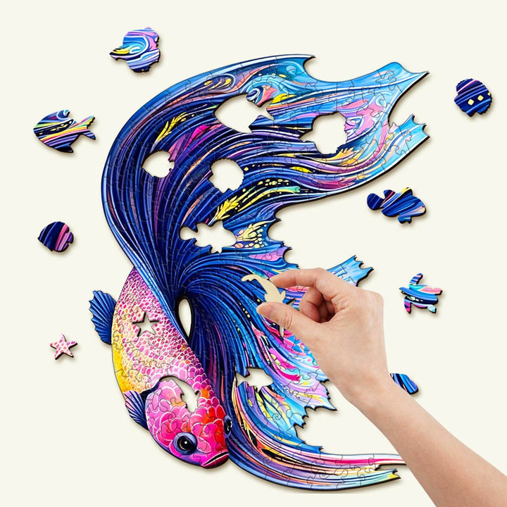 Wooden Half Moon Betta jigsaw puzzle with vibrant colors, unique shapes, showcasing a hand placing a piece.