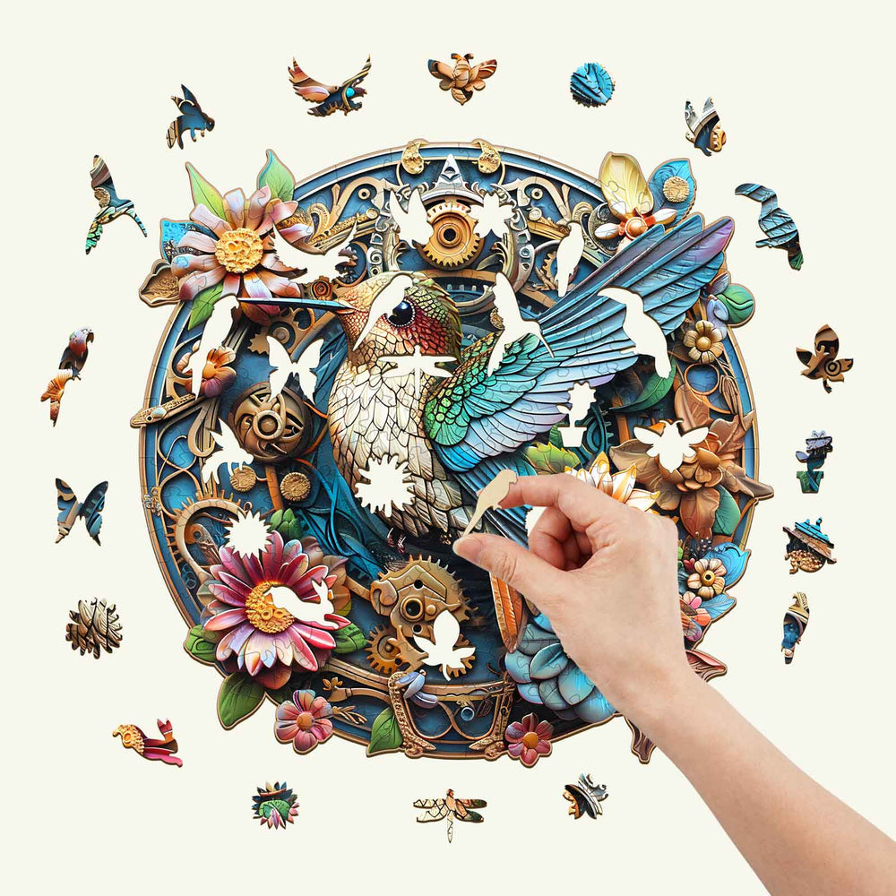 Person assembling the Graceful Hummingbird-2 wooden jigsaw puzzle, featuring vibrant colors and intricate designs.