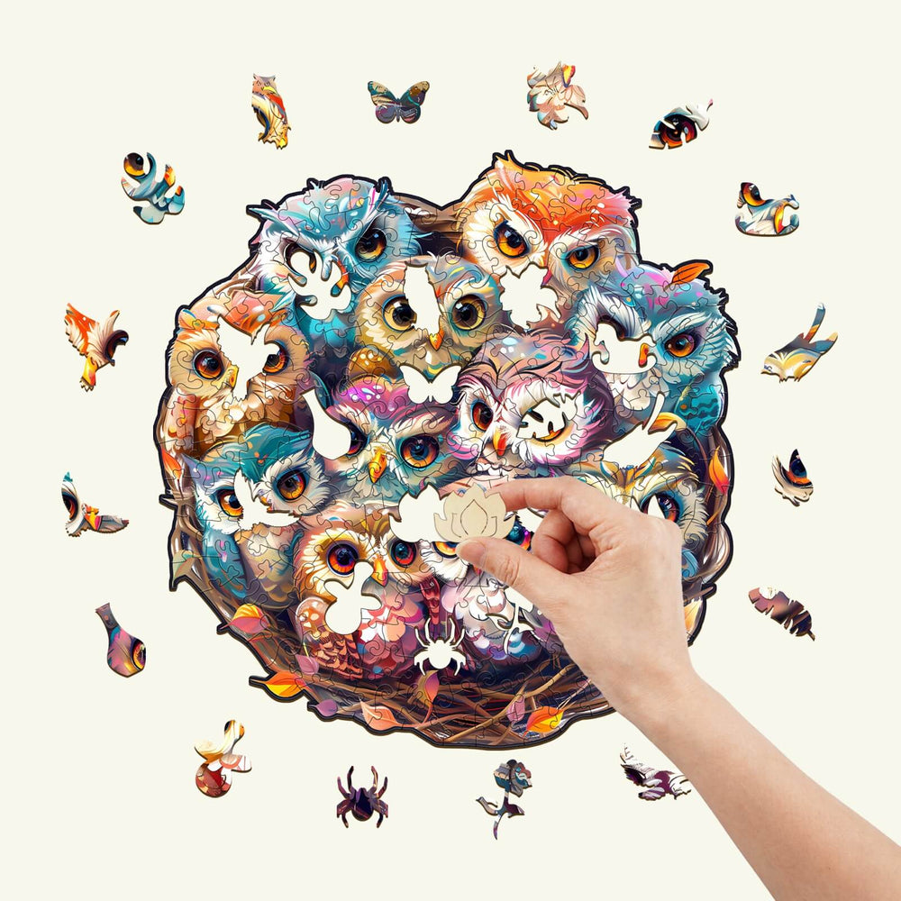 Colorful Baby Owls wooden jigsaw puzzle featuring a hand placing a piece, perfect for enhancing focus and cognitive skills.