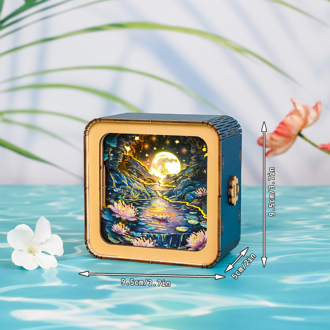 3D wooden puzzle night light featuring a moonlit lotus pond design, surrounded by tropical leaves.